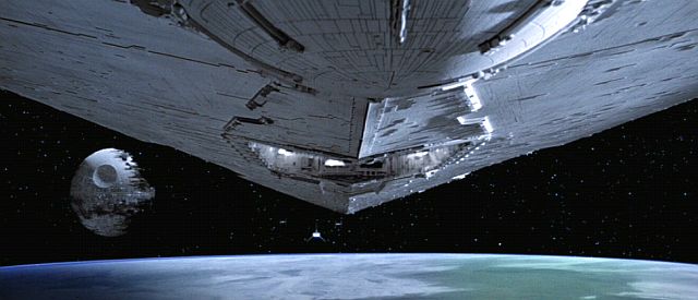 An Imperial Star Destroyer approaches the half-finished Death Star 2